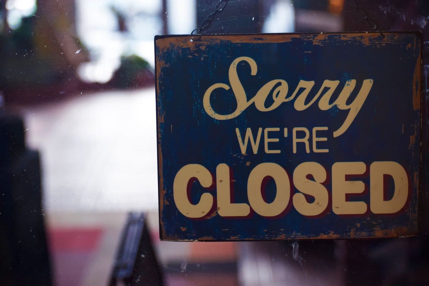 Sorry we are closed sign hanging in a shop window