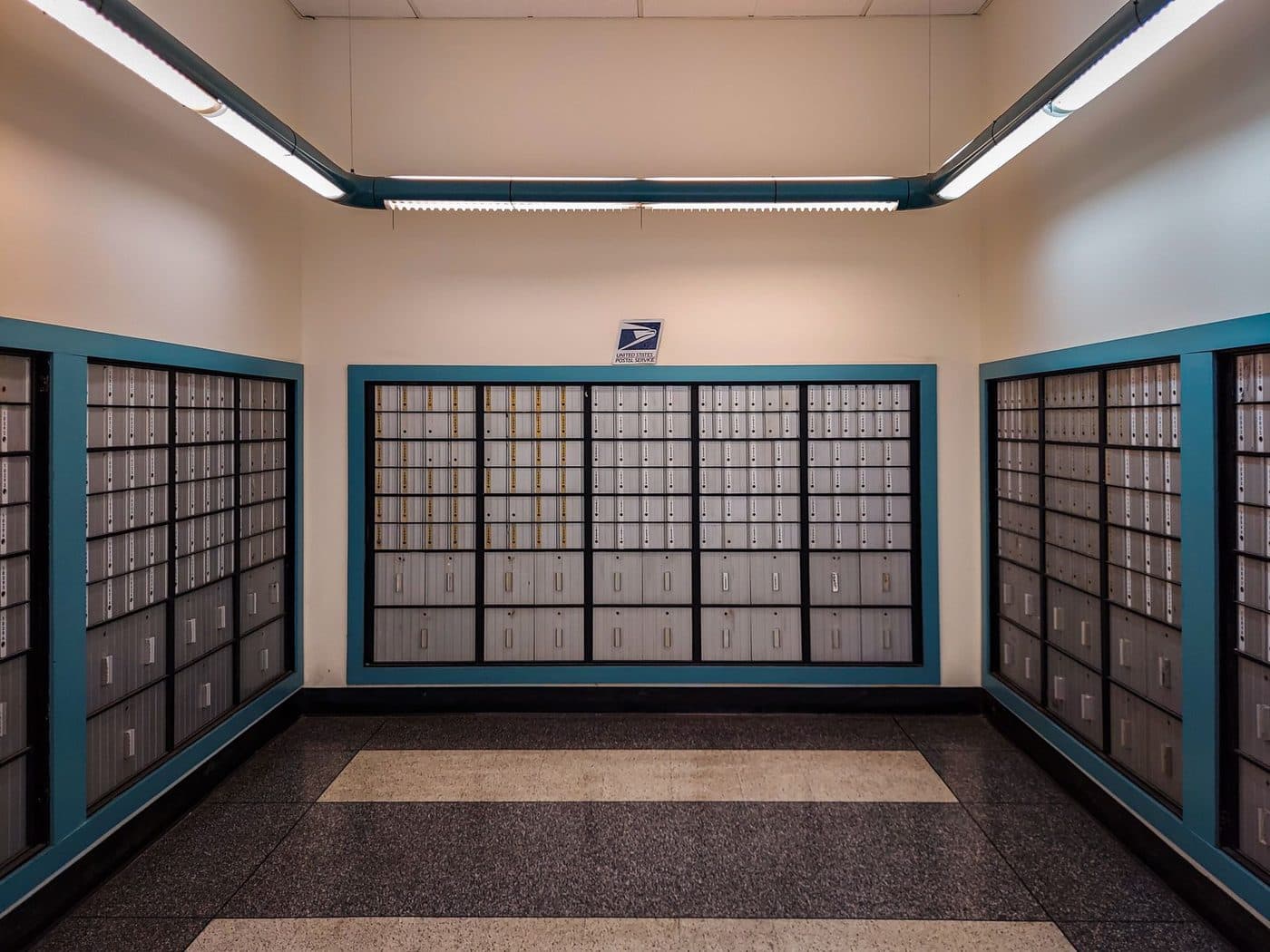 Rows of locked postal mailboxes in a post office interior