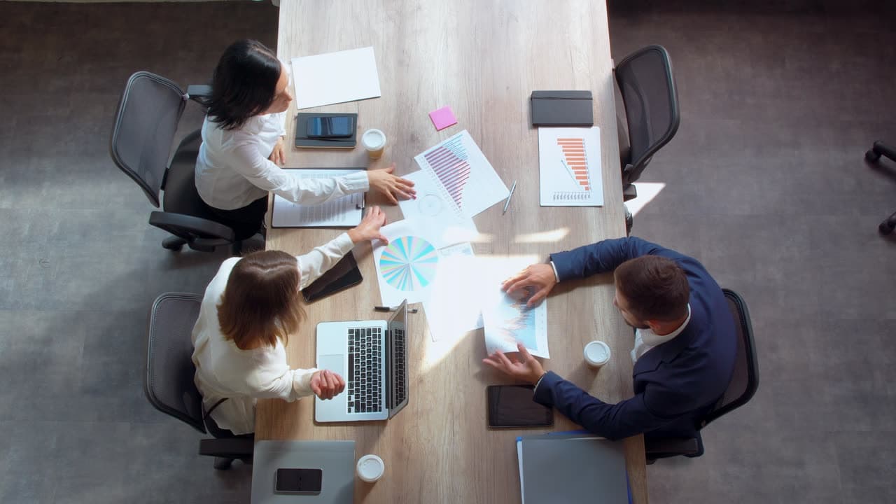 Two colleagues reviewing documents at a meeting table