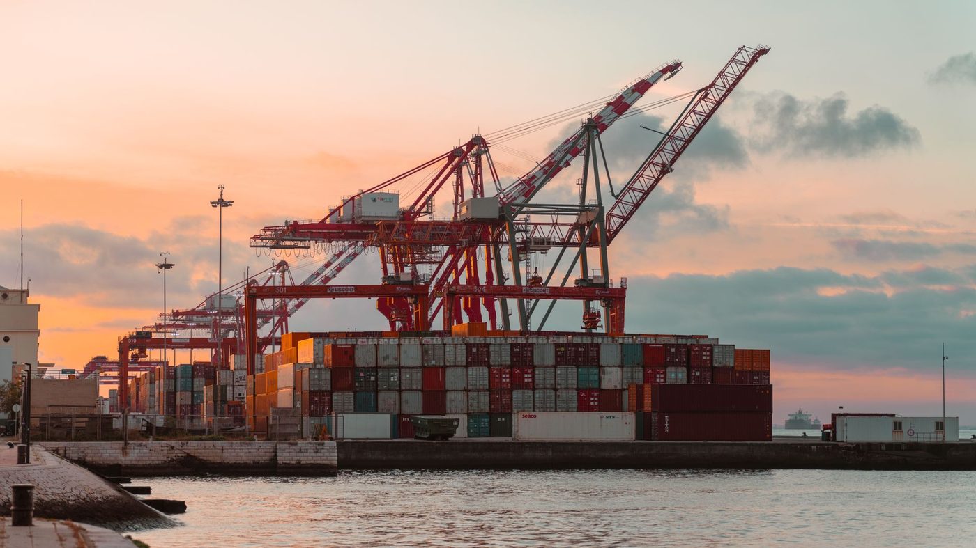 Cargo cranes and shipping containers at a river port terminal