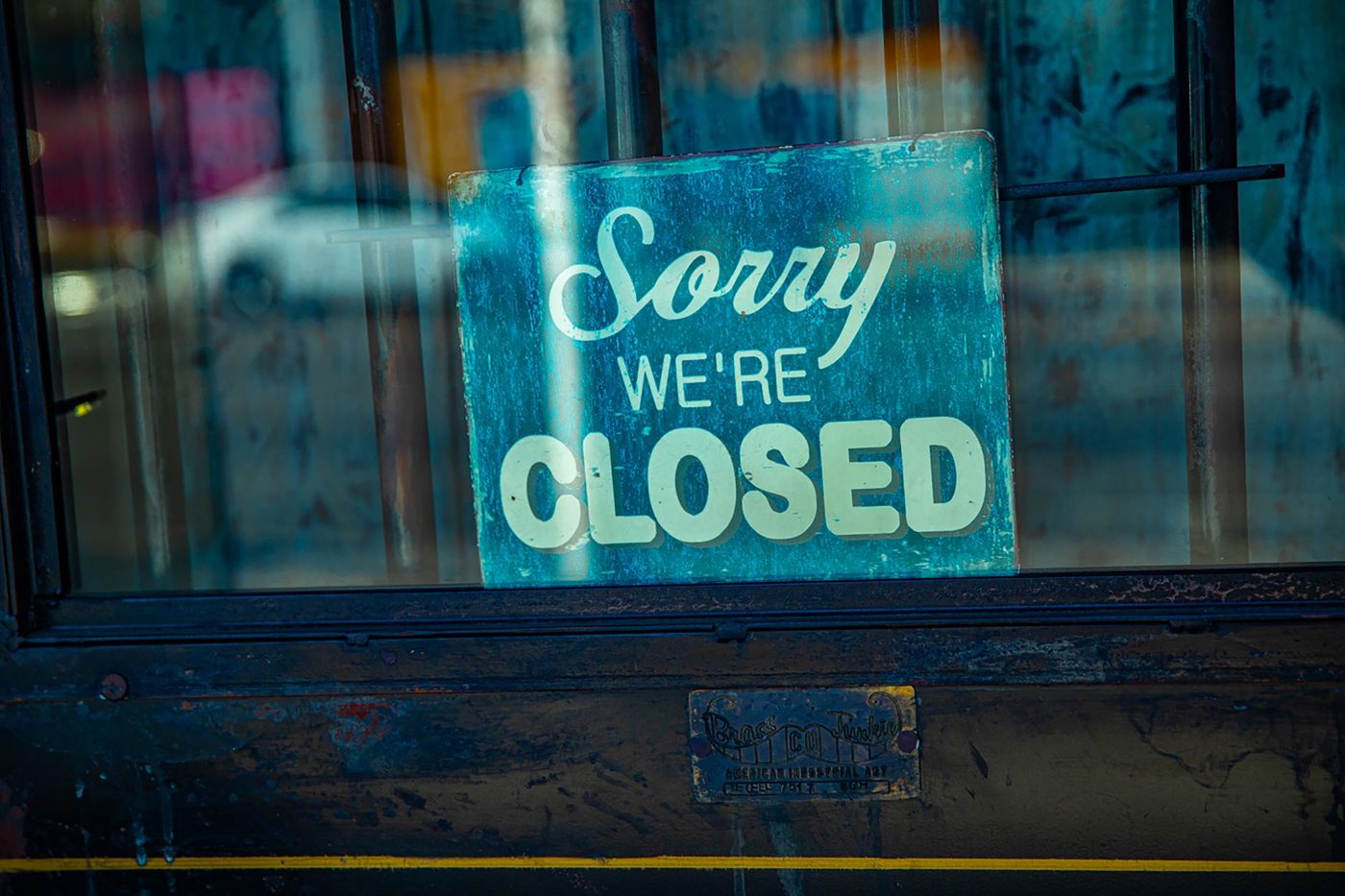 Closed sign hanging in the window of a small retail storefront