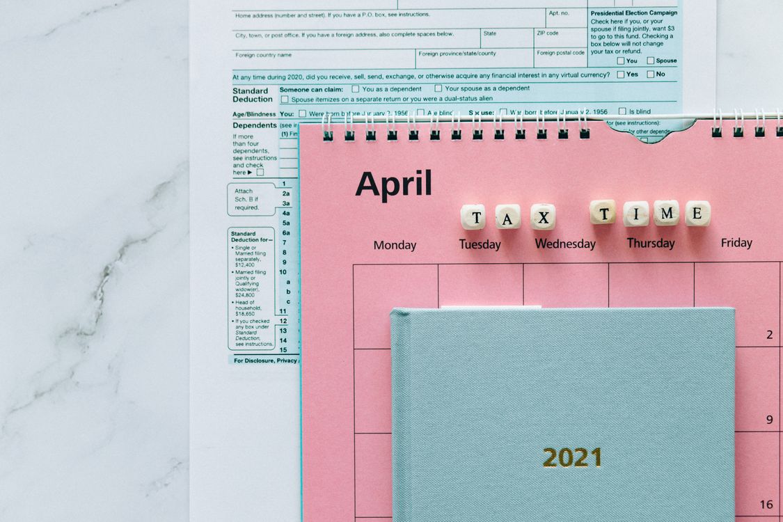 Tax forms and desk calendar representing business formation planning during spring tax season