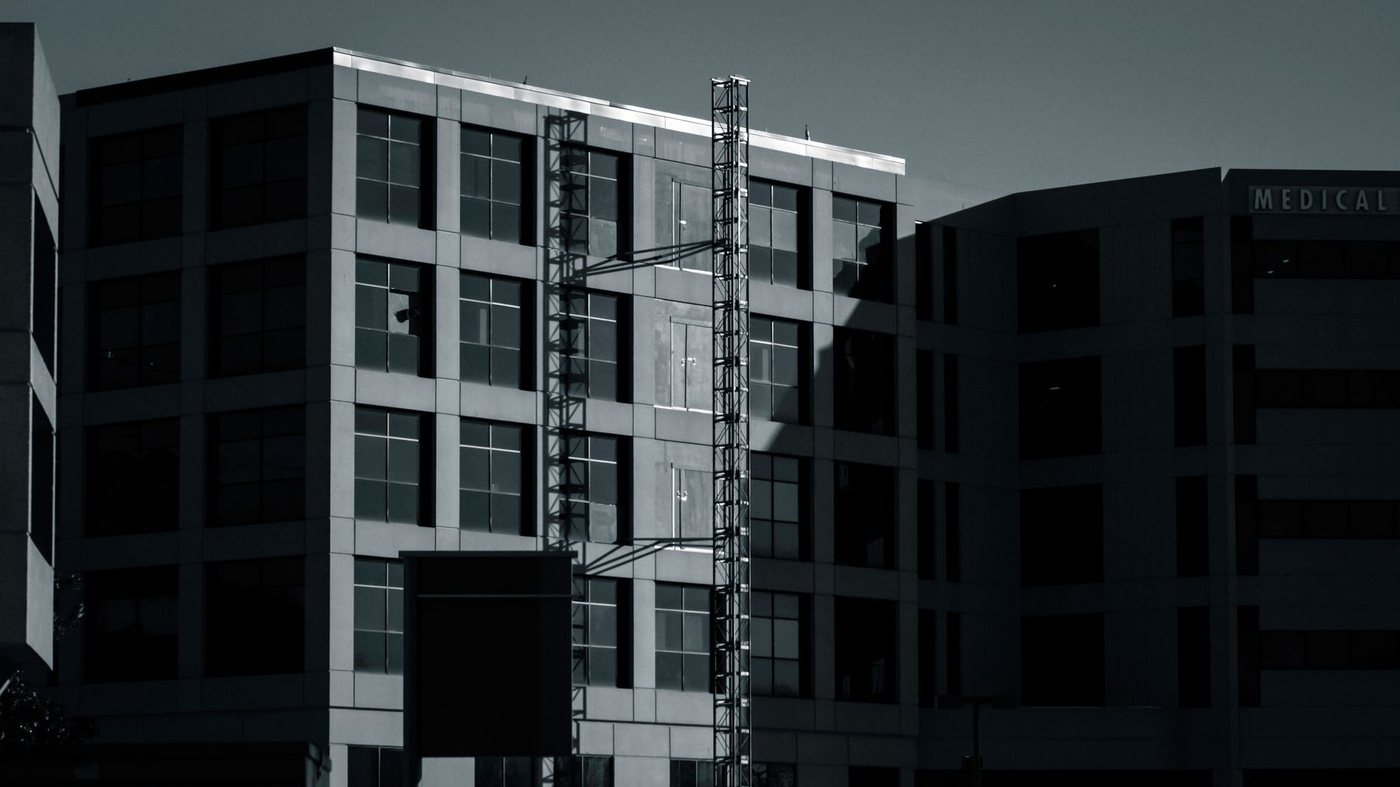 A dark monochrome view of a multi-storey medical office building with a neighbouring block carrying the word MEDICAL on its upper facade