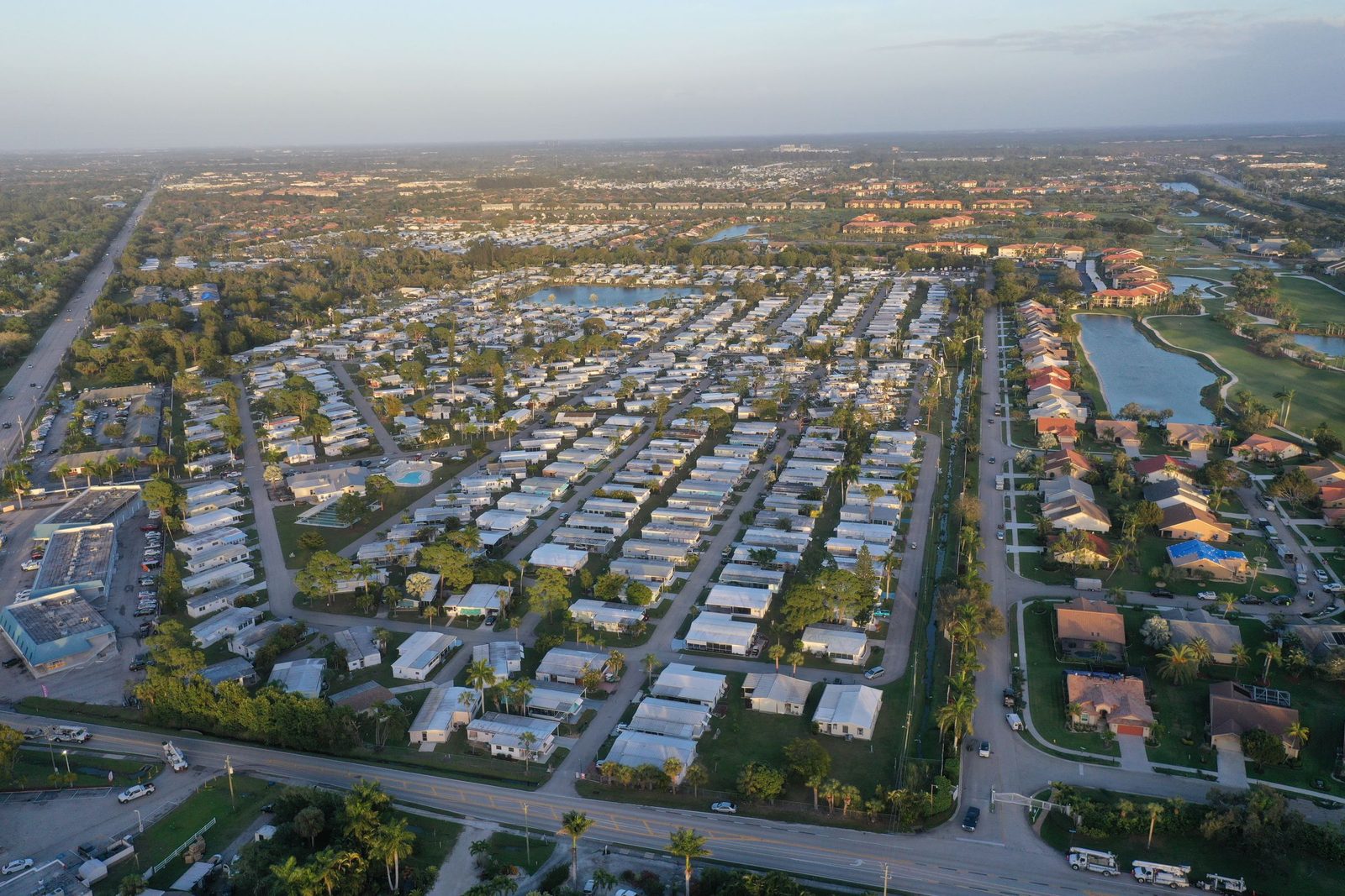 Aerial view of a Florida coastal town, rows of houses and a lake under morning light