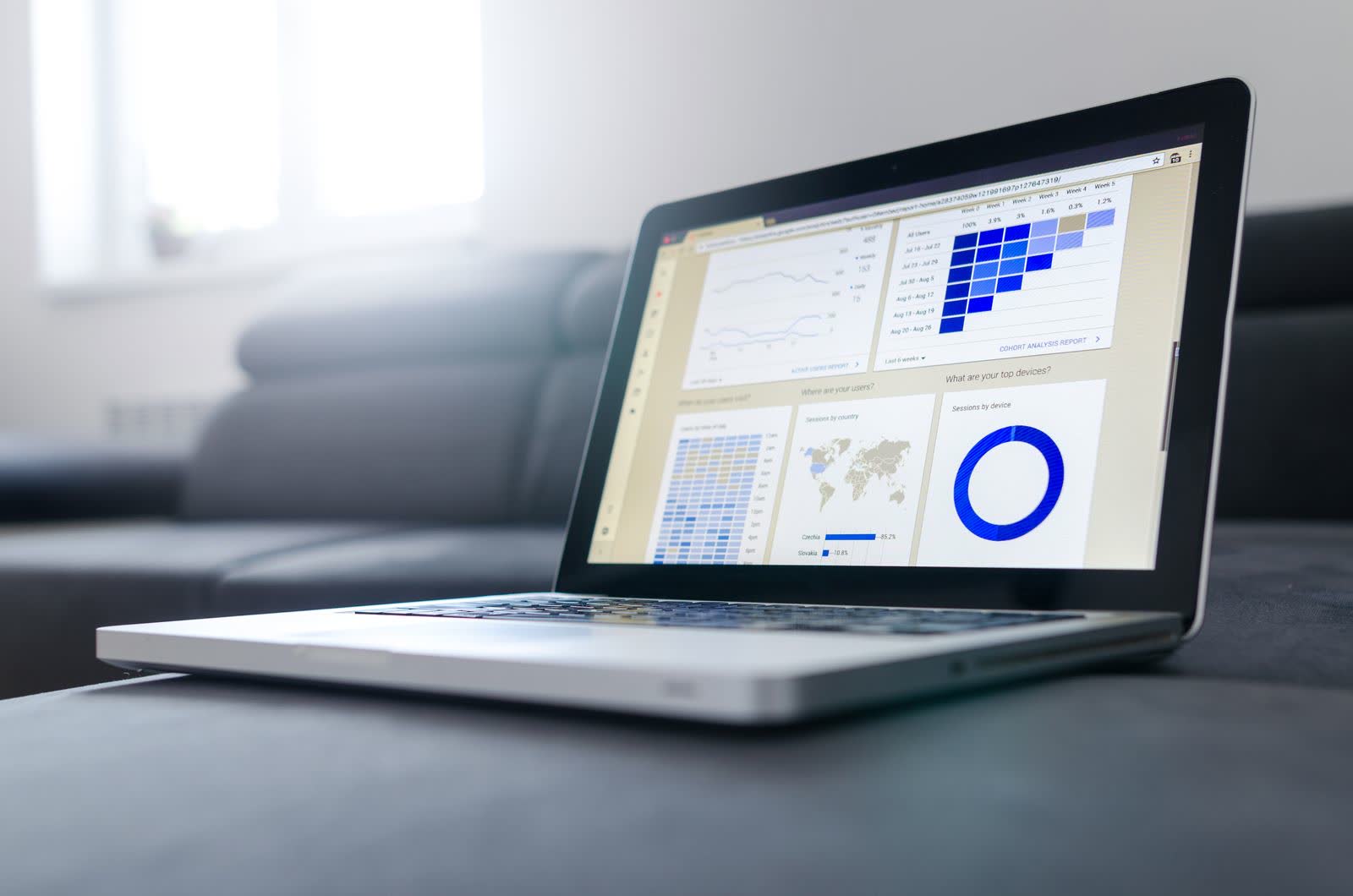 Laptop on a bright desk showing data dashboards and charts