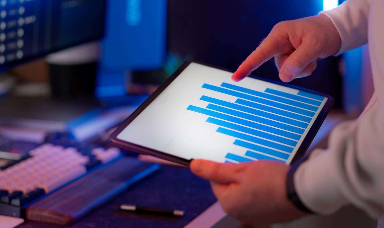Hand pointing at a bar chart on a tablet