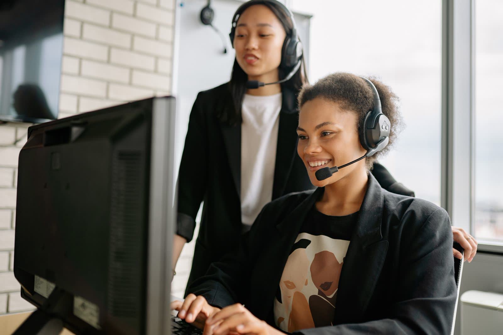 Mentor guiding an agent wearing a headset at a computer